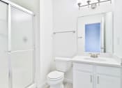 Thumbnail 16 of 102 - A white bathroom with a toilet, sink, and shower.