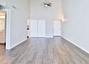 Thumbnail 43 of 47 - A room with a ceiling fan and wood flooring.