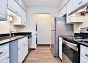 Thumbnail 41 of 47 - A kitchen with white cabinets and a black countertop.