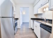Thumbnail 40 of 47 - A kitchen with a refrigerator on the left and a sink on the right.