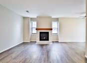 Thumbnail 30 of 39 - A room with a fireplace and wooden floors.