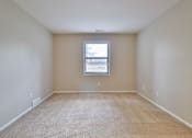Thumbnail 36 of 39 - A room with a window and carpeted floor.