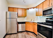 Thumbnail 23 of 33 - A kitchen with wooden cabinets and stainless steel appliances.