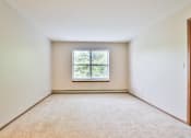 Thumbnail 25 of 33 - A room with a window and carpeted floor.