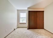 Thumbnail 26 of 33 - A room with a brown door and a window with blinds.