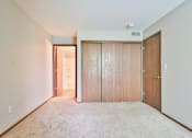 Thumbnail 27 of 33 - A room with a carpeted floor and two wooden doors.