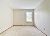 Thumbnail 32 of 33 - A room with a window and carpeted floor.