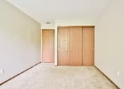 Thumbnail 33 of 33 - A room with two doors and carpeted floor.