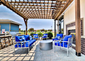 Thumbnail 18 of 75 - A patio with blue chairs and a wooden pergola.
