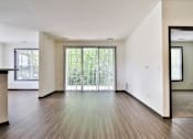 Thumbnail 81 of 102 - A spacious room with wooden floors and a large window with blinds.