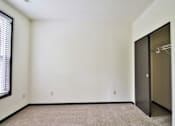 Thumbnail 85 of 102 - A room with a carpeted floor and a door on the right side.