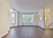 Thumbnail 90 of 102 - A spacious room with wooden floors and large windows.