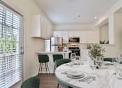 Thumbnail 9 of 93 - A modern kitchen with a dining table set for two.