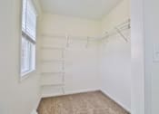 Thumbnail 96 of 102 - A white closet with a carpeted floor and a window.