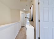Thumbnail 14 of 93 - A hallway with a white door and a painting on the wall.