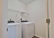 Thumbnail 15 of 93 - A white laundry room with a washer and dryer.