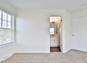 Thumbnail 99 of 102 - A white room with a carpet and a door leading to a kitchen.