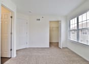 Thumbnail 100 of 102 - A white room with a carpeted floor and a window with blinds.