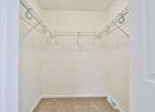 Thumbnail 101 of 102 - A white closet with a carpeted floor and a white door.