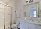 Thumbnail 17 of 93 - A white bathroom with a toilet, sink, and shower.