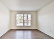 Thumbnail 33 of 33 - A room with a large window and wooden flooring.