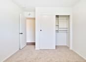 Thumbnail 26 of 33 - A white door is open to a room with a carpeted floor.