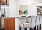 Thumbnail 26 of 31 - A kitchen with a white table and chairs.