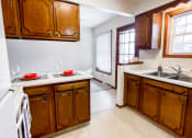 Thumbnail 13 of 27 - a kitchen with wooden cabinets and a white stove and a sink