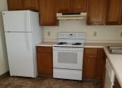 Thumbnail 1 of 5 - an empty kitchen with a white refrigerator freezer next to a white stove top oven