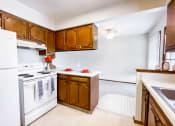 Thumbnail 12 of 27 - a kitchen with white appliances and wooden cabinets