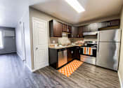 Thumbnail 14 of 27 - A kitchen with a refrigerator, oven, and sink.