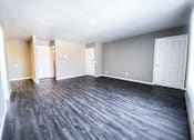 Thumbnail 21 of 27 - A room with a wooden floor and white walls.