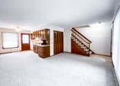 Thumbnail 14 of 27 - an empty living room with a staircase and a kitchen
