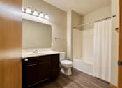Thumbnail 8 of 12 - A bathroom with a toilet, sink, and shower.