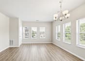 Thumbnail 3 of 12 - A large, empty room with wooden floors and a chandelier.