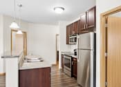 Thumbnail 4 of 12 - A kitchen with a refrigerator, sink, and cabinets.