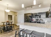 Thumbnail 28 of 75 - a kitchen with a large island with a breakfast bar and stools