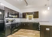 Thumbnail 27 of 75 - a kitchen with black cabinets and a white counter top