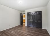 Thumbnail 26 of 44 - a empty living room with a black door and wooden floors