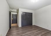 Thumbnail 23 of 44 - a empty room with a black door and wooden floors
