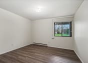 Thumbnail 21 of 44 - an empty living room with wood floors and a window