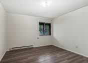 Thumbnail 20 of 44 - a living room with a window and a wooden floor