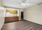 Thumbnail 18 of 44 - a empty living room with a kitchen and a ceiling fan