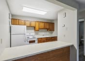 Thumbnail 15 of 44 - an empty kitchen with white appliances and wooden cabinets