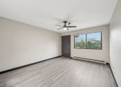 Thumbnail 7 of 44 - an empty living room with a window and a ceiling fan