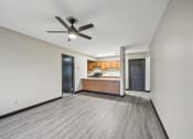 Thumbnail 6 of 44 - an empty living room with a ceiling fan and a kitchen