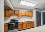 Thumbnail 5 of 44 - a kitchen with wooden cabinets and black appliances and a sink