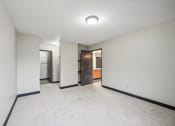 Thumbnail 11 of 44 - a empty living room with white walls and a door to a bathroom