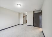 Thumbnail 13 of 44 - a living room with white walls and a door to a hallway
