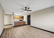 Thumbnail 30 of 44 - a empty living room with a ceiling fan and a kitchen